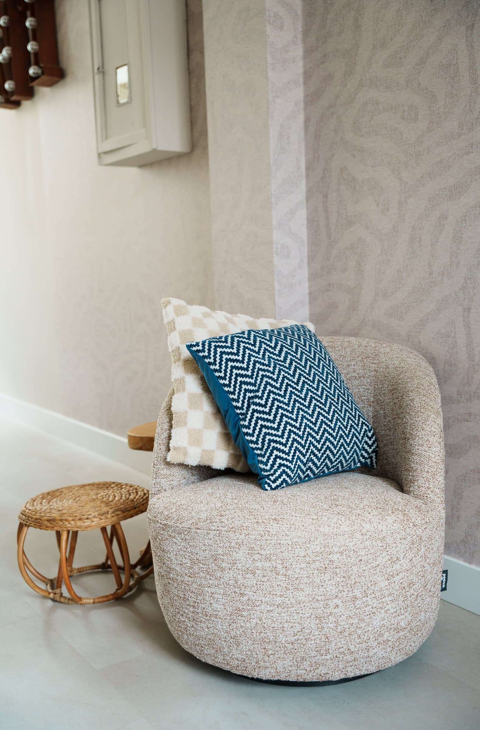 Bouclé fauteuil met kussens in een licht interieur
